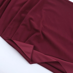 Detailed close-up of burgundy V-neck dress fabric showing stitching and matte texture