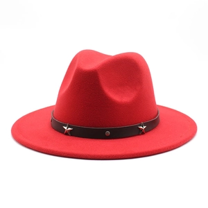 Detail of red wool felt fedora featuring a black leather band with silver star rivets