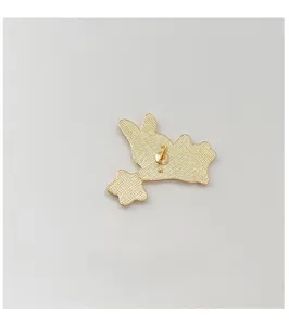 Detail of the light gold alloy brooch back with sandblasted texture and safety pin stud