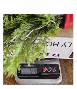 Close-up of lightweight Christmas gnome wreath weighing 124g on a digital scale