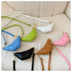 Multi-color mini croissant crossbody bags in textured PU leather displayed on a soft sofa