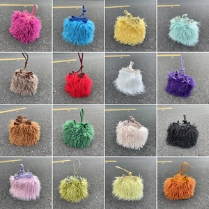 Multiple colors of faux sheep fur bucket bags with drawstring closure in a grid view