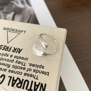 Macro detail of silver irregular water drop ring with a polished mirror finish surface