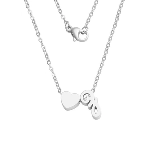 Detail of silver heart pendant and S-letter charm on a stainless steel chain