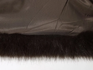 Gros plan sur la doublure marron foncé et le col en fausse fourrure du manteau court