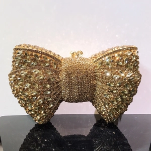 Macro shot of gold bow clutch bag fully encrusted with sparkling crystals and rhinestones