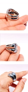Three-angle macro shots showing a chunky silver ring with a large oval zircon stone
