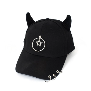 Detail view of black punk baseball cap with metal rings, star charms and devil horns