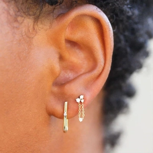 Close-up of 925 silver gold tassel earrings with zircon studs worn by a model