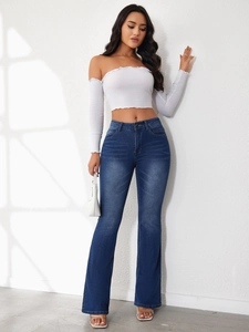 Fashionable high waist flared denim jeans paired with white off-shoulder crop top and heels