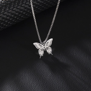 Collier avec pendentif papillon minimaliste en acier inoxydable sur fond de cuir noir