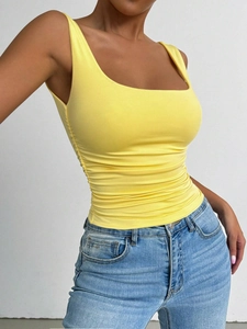Detailed view of yellow slim-fit tank top featuring side ruched details and U-neckline