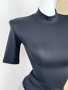 Detail of black slim fit T-shirt featuring shoulder pads and a mock neck design