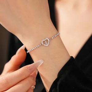 Elegant silver bracelet with zircon heart charm and Virgin Mary relief on model's wrist