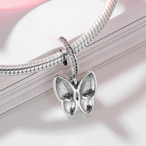 Sparkling S925 sterling silver butterfly charm with crystals on a white book page