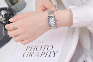 Close-up of rectangular quartz watch with silver stainless steel band and Roman numerals