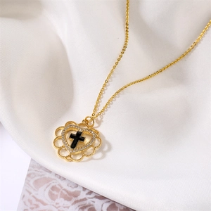 Macro detail of gold heart pendant with black cross and shimmering zircon inlay