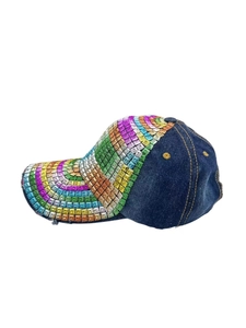 Dettaglio cappello denim blu con borchie quadrate colorate e bordo visiera consumato