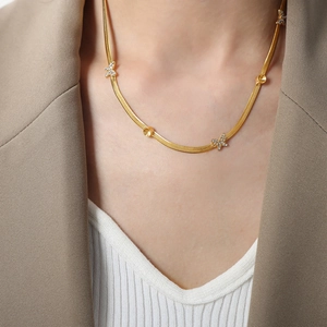 Collier chaîne serpent dorée avec pendentif papillon étincelant sur un mannequin élégant