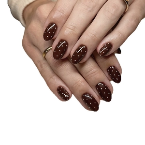 Braune ovale Kunstnägel mit weißen Punkten für minimalistisches Herbst-Nageldesign