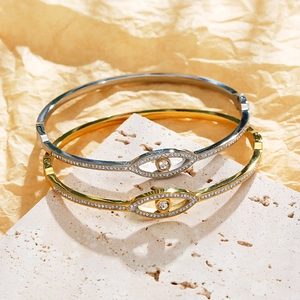 Polished gold and silver evil eye bracelets with sparkling crystals on stone