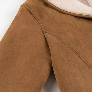 Detailed close-up of shoulder stitching on brown faux suede coat with white faux shearling