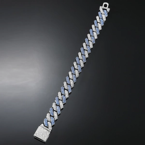 Detail of hip hop Cuban link bracelet with blue and clear zircon crystals on grey background