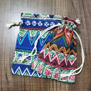 Macro detail of cotton drawstring bags with ethnic geometric patterns on wood surface