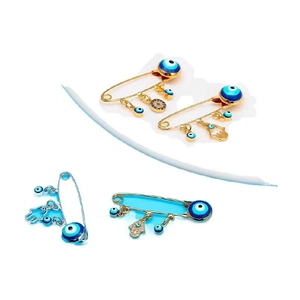 Detail of four safety pin brooches featuring evil eye and hand of Fatima charms
