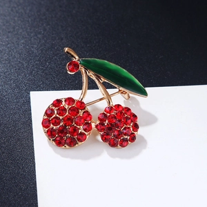 Elegant cherry brooch with red rhinestones and green enamel leaf in golden finish