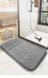 Détail du tapis de bain gris pelucheux avec texture douce à poils longs et envers antidérapant