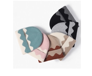 Flat lay of warm jacquard knit beanies in six colors with wavy patterns on white background