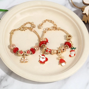 Christmas DIY charm bracelet set with gold Santa and reindeer pendants on marble surface