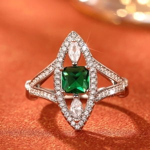 Macro detail of emerald-cut green stone ring with marquise zircons and silver plating