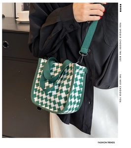 Detail of green and white checkered tote bag featuring canvas handles and woven texture