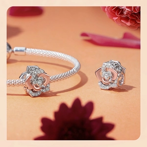 Macro shot of S925 silver rose flower charms with sparkling zircons on a snake chain
