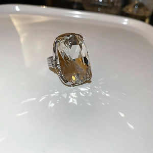 Detailed view of silver oval zircon ring with radiant light reflections and sparkling finish