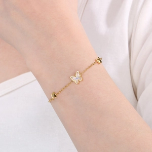 Detail of a gold stainless steel butterfly bracelet with sparkling zircon on model wrist
