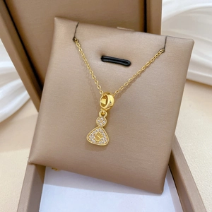 Macro shot of gold-plated necklace with sparkling S letter pendant in a jewelry box