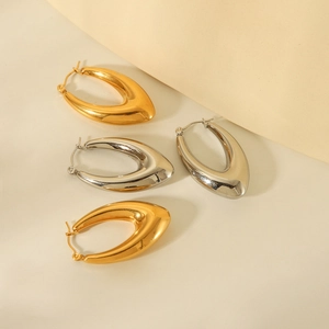 Macro shot of polished gold and silver water-drop style chunky hoop earrings set