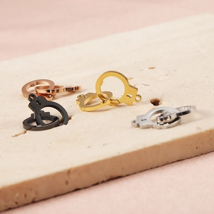 Close-up of handcuff pendants in gold, silver, rose gold, and black stainless steel