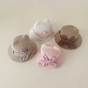 Detailed view of four straw sun hats with cat ears and large bows in various soft colors