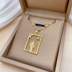 Luxurious gold titanium necklace with Hamsa hand rectangular pendant in a velvet box