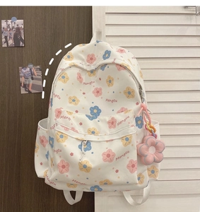 Detail of floral patterns and Mengtu printing on beige casual backpack with plush charm