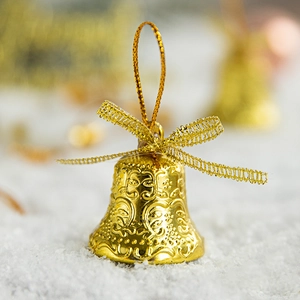 Golden Christmas tree bell decoration with embossed floral patterns and a mesh bow