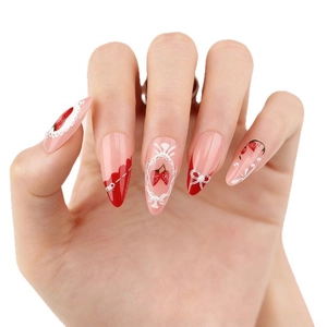 Almond press-on nails featuring red French tips, strawberry art, and pearl bows