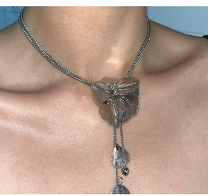 Macro shot of silver oversized floral pendant necklace with cascading leaf fringe