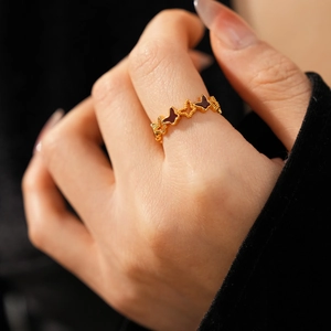 Detail of 18k gold butterfly ring featuring red enamel drip oil and hollow lace design