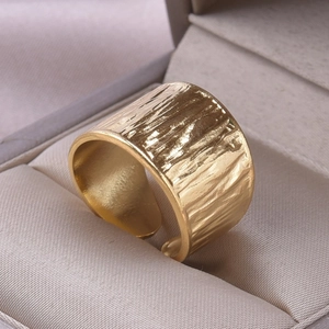 Macro detail of gold hammered texture on adjustable stainless steel band ring
