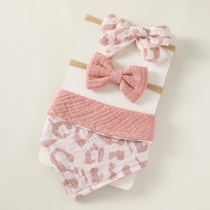Three-piece baby gift set with pink bow headbands and a soft leopard print cotton bib